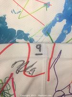 Close-up of player's autograph with number 9 written near signature on sock.