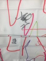 Close-up of autograph and number 13 on the white hockey sock with colorful designs.