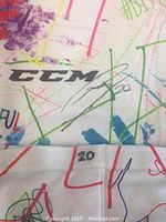 Close-up of the CCM logo with Roland McKeown's autograph and number 20 visible on the sock fabric.
