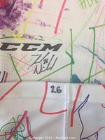 Close-up of the autographed CCM branded sock with player number 26 visible and Ted Nichol's signature.