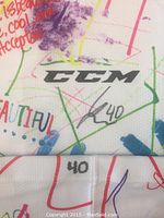 Close-up photo showing the CCM logo, player autograph, and number 40 on the white hockey sock.