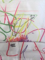 Close-up photo of Corey Pawley autograph and number 92 on the colorful sock.