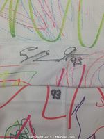 Close-up of autograph “Sam Bennett” in black marker above printed number “93” on white sock with multicolor scribbles.
