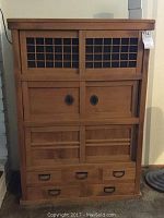 Front view of entire chest showing lattice doors, panel doors and bottom drawers.