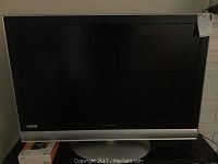 Front view of the Mitsubishi 36-inch flat screen television showing black screen and silver base.