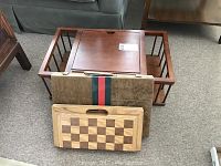 Wooden lap table with backgammon and chess boards arranged in front on carpeted floor.