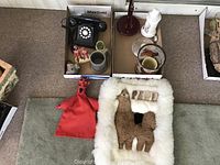 Overview of assorted decorative items including wool hanging, hand puppet, mug, vintage telephone, and small figurines