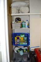 Tall closet shelf showing cleaning products including Clorox wipes, Tuff Stuff, and several cleaning accessories in organized bins and boxes.