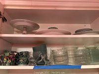 Overview shelf with Magic Jungle mugs, glass bowls and saucers, blue-grey ceramic mugs.