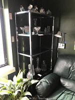 Full view of 5-tier display shelf with glass shelves and metal frame, styled with glassware