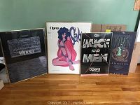 Four framed vintage opera posters displayed side by side on a hardwood floor, featuring Salome and others.