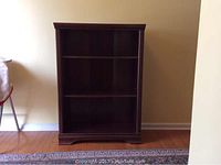 Front view of the dark brown wooden bookcase with two shelves.
