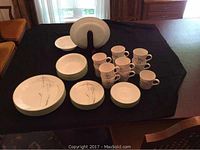 Full set laid out on black cloth showing all plates, bowls, cups and saucers with Shadow Iris pattern visible