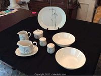 Full set of Corelle Shadow Iris serving pieces on black table: oval platter, 2 round serving bowls, creamer with plate, sugar bowl with lid, gravy boat with plate, salt and pepper shakers