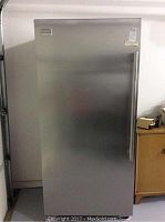 Front view of stainless steel upright freezer with closed door.