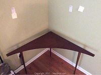 Front view of triangular corner table placed against walls