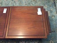 Top view of three stacked walnut nesting tables showing wood grain and inlaid borders.