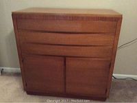 Front view of the oak sideboard cabinet with three drawers and two door panels below.