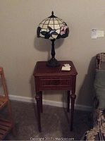 Side view of the side table with drawer and Tiffany style lamp on top