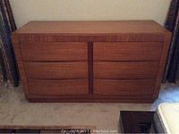 Front view of mid-century modern dresser showing six drawers and wood veneer finish in warm brown color.