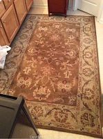 Full view of the rectangular brown tone rug with floral accents, showing the overall design and size.