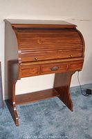 Full front angled view of the wood roll top desk showing the tambour cover and drawer configuration.