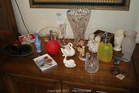 Full view of items on buffet surface including crystal vases, figurines, glass bottles, and tableware.