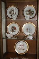 Front view of three shelves with Lenox Boehm Woodland Animal plates, floral vase, teacup, shell dish, covered bowl, and Cybis turtle.