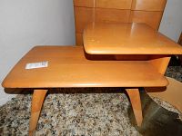 Front angled view showing the two-tier design and tapered legs with light finish wear.