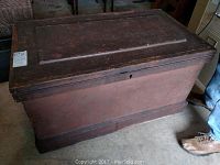 Front view of rectangular wooden trunk with hinged lid