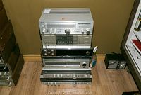 Stack of six amplifiers and receivers including Sony STR-333, Pioneer SX-6, Heathkit AR-1500, Yamaha R-100, Onkyo TX-3000 and TX-8000 visible from front and slightly above, showing front control panels and wear.