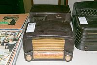 Two vintage radios placed side by side, including the GE Model C600 with curved front and Emerson with rectangular front and square speaker grill.