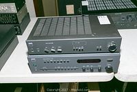 Photo showing two stacked NAD audio devices on a white table: Stereo Amplifier 3020 on top, Receiver C 740 below, both black units with control knobs and switches visible.