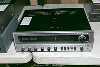 Front and top view of Fisher 205 stereo receiver showing control knobs and vents.