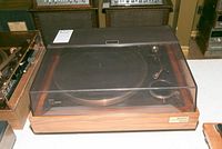 Sony Model 5520 automatic turntable with closed brown transparent dust cover and wood base.