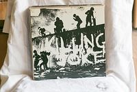 Killing Joke vinyl record album cover shown upright against white fabric background.