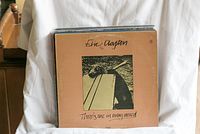 Front view of a vinyl LP record 'There's One in Every Crowd' by Eric Clapton among the stack
