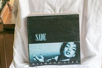 Front cover of Sade's 'Diamond Life' vinyl record showing portrait photo of Sade.
