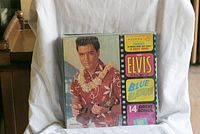 Front cover of Blue Hawaii Elvis Presley vinyl record showing Elvis in Hawaiian shirt and lei with title text.