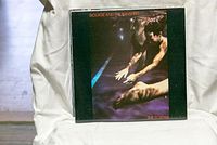 Front cover of The Scream vinyl album showing artwork with person stretching or jumping in a dark, purple and black background.