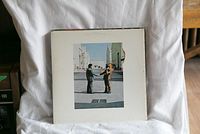 Photo of the Wish You Were Here album cover showing two men shaking hands in front of an industrial background