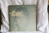 John Lennon Imagine album cover with faded image of John Lennon and clouds