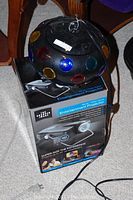 Projector atop its original box showing front and packaging details.