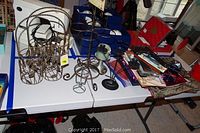 Wide photo showing metal wine holders, small globe, red gumball machine, picture frames, and other decor on table.