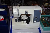 Full view of the Kenmore portable sewing machine showing machine body and cords.