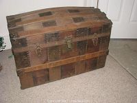 Front and side profile of antique wooden steamer trunk with metal reinforcements and lock plate.