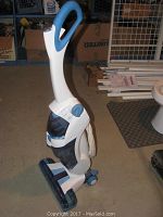 Full view of Hoover Floormate upright vacuum cleaner with visible tanks, cord, and handle in white and blue colors.