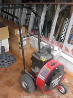 Front and side view of the Briggs and Stratton powered Giant-Vac Classic vacuum unit with black handle and large rear wheels.