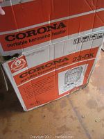 Original cardboard box labeled 'CORONA portable kerosene heater 23-DK' with printed graphic of the heater.