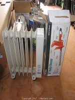 Photo showing 16 inch hedge trimmer in box beside a portable oil-filled radiator heater